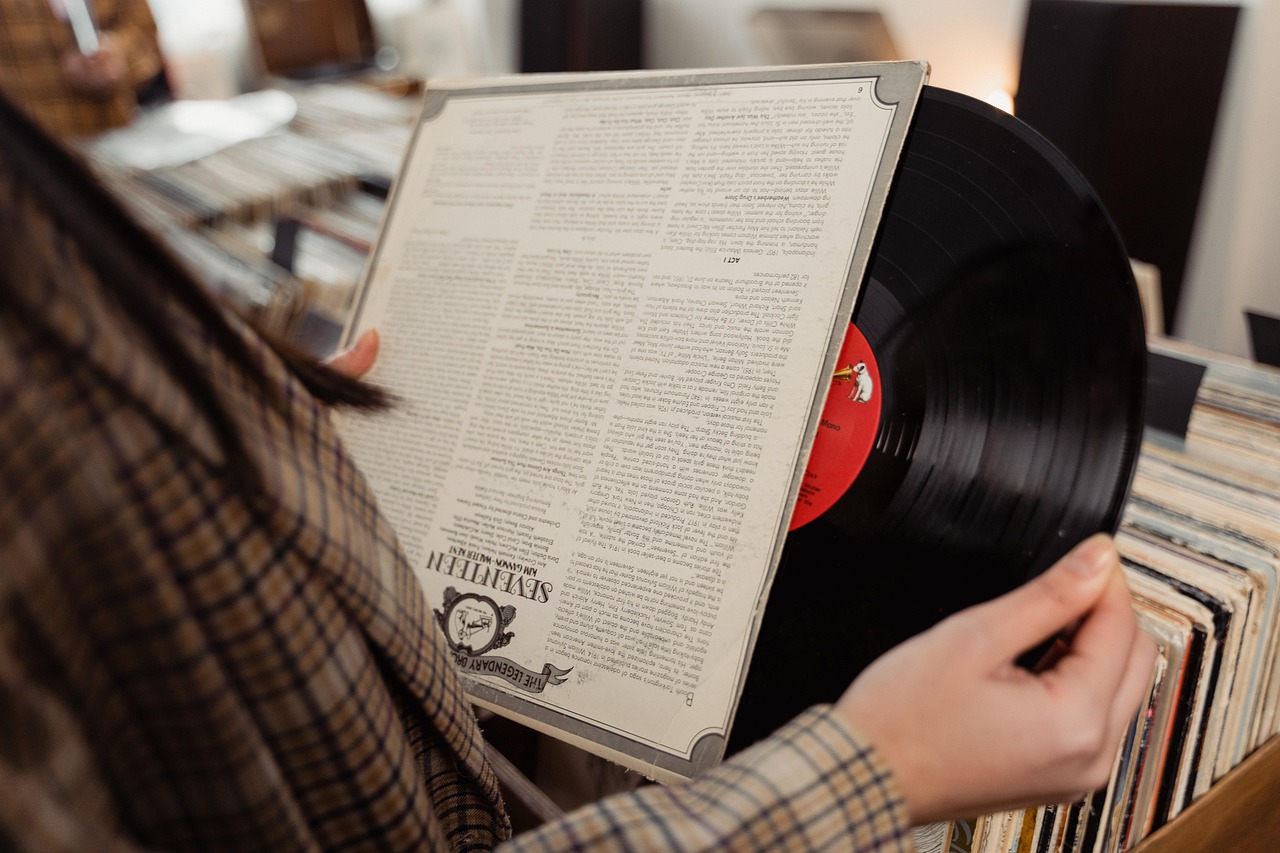 Persoon bekijkt een vinyl LP met hoes in een platenzaak