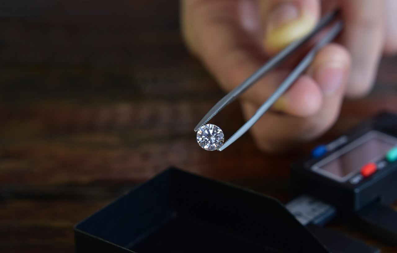 Geslepen diamant in pincet bij de juwelier, voorbeeld van edelsteen taxatie